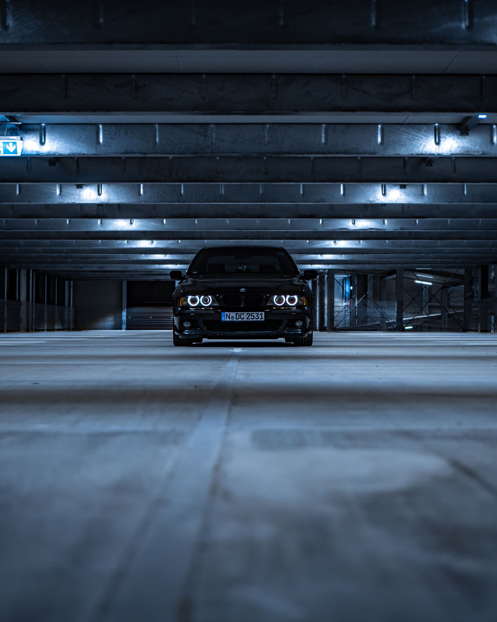 Schwarze Limousine in beleuchteter Parkgarage